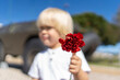 Kid holding red clove for 25 of April, celebration of 50 Years, Portugal freedom day. Revolution of the Carnations 1974.