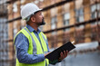 © Michael Cunningham/peopleimages.com - Always make sure of the rules. Shot of a contractor filling out paperwork at a construction site.