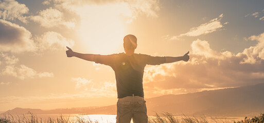 Wellness and health. Young man in field feeling free and energized in at the warm morning light 