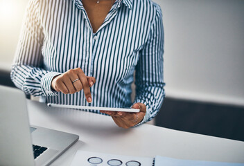 Poster - Technology always helps to improve her plans. Closeup shot of an unrecognizable businesswoman working on a digital tablet in an office.