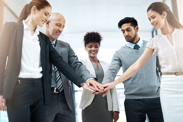 Poster - Success is even better when its shared. Shot of a diverse team of colleagues joining their hands together in solidarity.