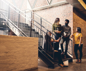 Poster - Theyre a tightly knit team. Full length shot of a group of young designers gathered in a stairwell at the office.
