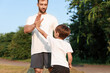 © Pixel-Shot - Father giving high-five to his little son in park