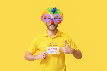 Poster - Funny young man in disguise and with card on yellow background. April fools' day celebration