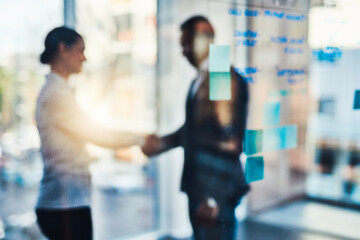 Canvas Print - Determined to achieve success. Defocused shot of two businesspeople shaking hands in an office.