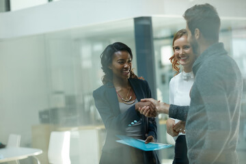 Poster - Welcoming a new member to the team. Cropped shot of businesspeople shaking hands in an office.