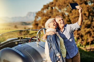 Sticker - Taking a selfie for the grandkids. Shot of a senior couple posing for a selfie while out on a roadtrip in a convertible.