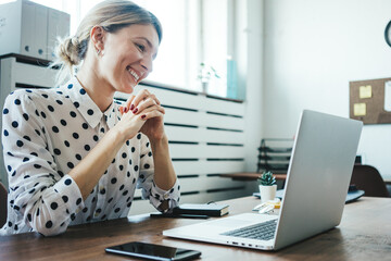 Wall Mural - Pretty smiling woman working with laptop. Video online conference