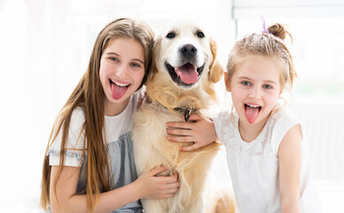 Wall Mural - Funny Portrait of little girls with cute dog in bright room