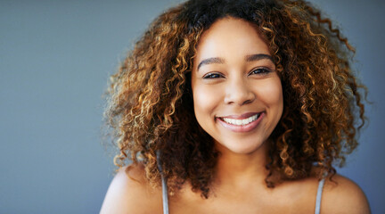 Poster - Smile because you can. Studio shot of an attractive young woman against a grey background.