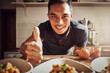© Clement Coetzee/peopleimages.com - Food fit for a king. Portrait of a young man showing thumbs up while preparing a delicious meal at home.