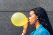 © Dani D.G - Black woman inflating yellow balloon