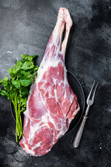 Poster - Ready for cooking  raw lamb mutton leg with Thigh. Black background. Top view