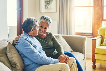 We still talk for hours on end. Shot of an affectionate senior couple relaxing on a sofa together at home.