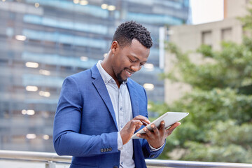 Canvas Print - Hes got all the connections. Shot of a young businessman using a digital tablet against a city background.