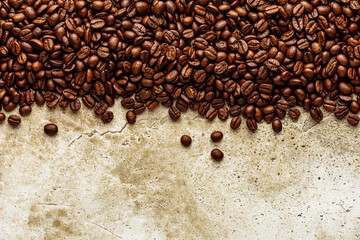 Wall Mural - Roasted coffee beans over scratched stone wall texture. Top view on background copy space