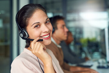 Poster - Excellent customer service goes a long way. Portrait of a call centre agent working in an office with her colleagues in the background.