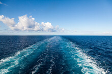 The Trail From The Movement Of The Ship In The Sea Stretching Into The Horizon With A Clear Sky With Clouds.