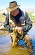 A stream fisherman with a brown trout 