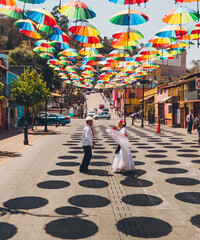 Wall Mural - Aerial photo of dancers of typical Mexican dances from the downtown region, doing their performance in the street adorned with colored umbrellas.