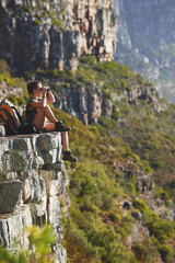 Wall Mural - Problems seem a lot smaller when youre out in the mountains. Shot of a woman using binoculars while out in the mountains.