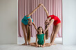 Three sisters doing gymnastics in a white studio