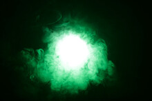 Artificial Magic Smoke In Green Light On Black Background