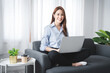 © Daenin - girl sitting on the sofa at home working on the computer. beautiful smile