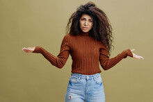 WHAT CONCEPT. Confused Gorgeous Curly Caucasian Female Look At Camera, Hold Hands Up, Say What. Copy Space For Clothing Fashion Brands, Free Place For Ad. Studio Shoot Isolated With Green Background
