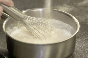 Wall Mural - Whisk in pot of melting butter, closeup