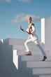 © Nicholas Felix/peopleimages.com - Unusual I take that as a compliment. Shot of a young model wearing stylish white clothes while walking up stairs against a sky background.