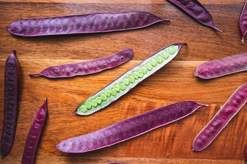 Wall Mural - Guaje seed pods are scattered on a wood table in Oaxaca, Mexico.