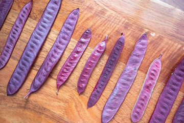 Wall Mural - Purple Guaje seed pods are arranged in a pattern on a table.