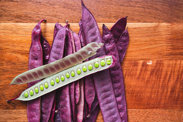 Wall Mural - Pile of purple Guaje pod seeds on a wood table in Oaxaca Mexico. There is an open pod with seeds inside.