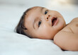 © Kay Abrahams/peopleimages.com - A cutie pie for sure. Shot of an adorable baby girl lying on a bed at home.