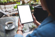 © Farknot Architect - Mockup image of a woman holding digital tablet with blank white desktop screen in the outdoors cafe