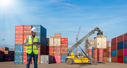 Fototapete - Engineer wearing uniform inspection and see detail on tablet with logistics container dock cargo yard with working crane bridge in shipyard with transport logistic import export background.