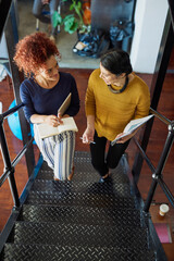Poster - Discussing business on the go. Shot of two designers discussing something in an office.