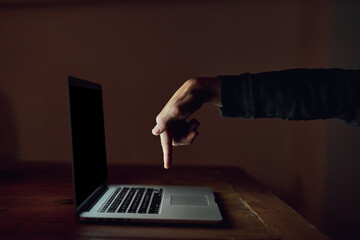 Wall Mural - And... send. High angle shot of an unidentifiable man using a laptop late at night.