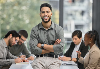 Poster - How quickly life can turn around. Portrait of a young businessman at the office sitting in front of his colleagues having a meeting in the background.