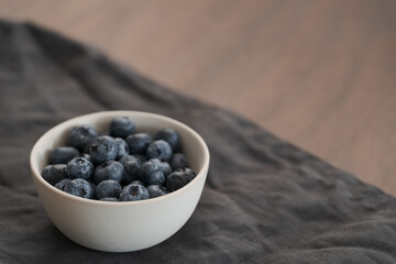 Wall Mural - Fresh washed blueberris in white bowl on linen cloth