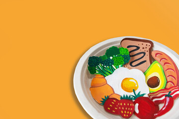 Plate with breakfast made from paper cut: bread, tomato, avocado, strawberry, ham, hotdog, chili, broccoli, croissant, on white background. healthy or food art concept. Copy space. Top view