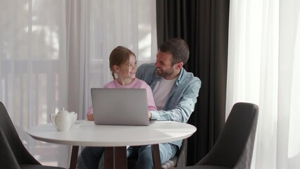 Wall Mural - Father and daughter using laptop computer together in the room