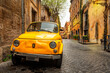 Vintage yellow car on the street of Rome, Italy. Rome architecture and landmark.