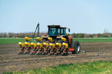 Sticker - Agricultural tractor with seeder machine at work on the field