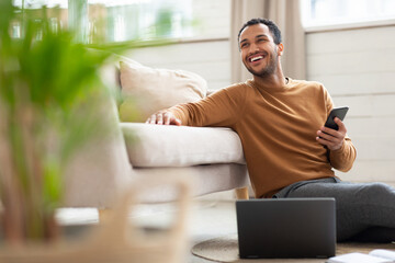 Aufkleber - Young Arab man holding phone using pc at home