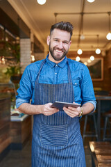 Poster - I can now easily track my supply deliveries online. Portrait of a business owner using a digital tablet in his store.