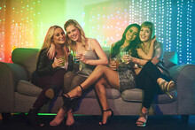 Tonight Is Reserved For The Ladies. Shot Of A Group Of Friends Having Drinks On A Sofa At A Party.