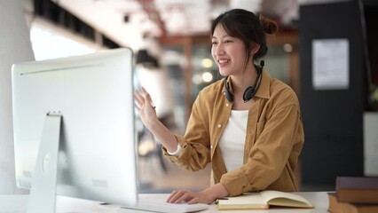 Wall Mural - Happy young asian woman smiling while studying on computer pc at home. online class and home study concept