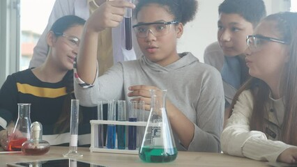 young teacher teaching group student about science and explaining chemical for liquid in the lab of 